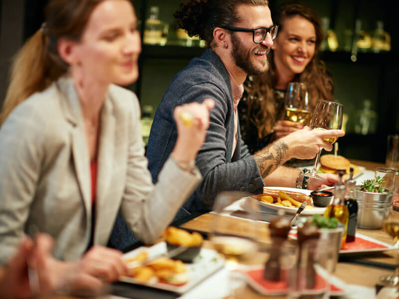 Best Friends Sitting In Restaurant For Dinner, Drinking Wine And