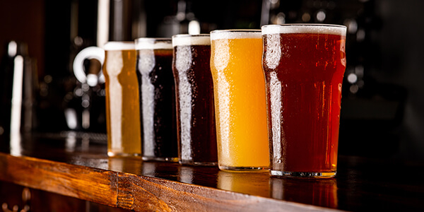 Many Varieties Of Craft Beer. Misted Glass Goblets With Ale, Lager, And Unfiltered Drink On Bar
